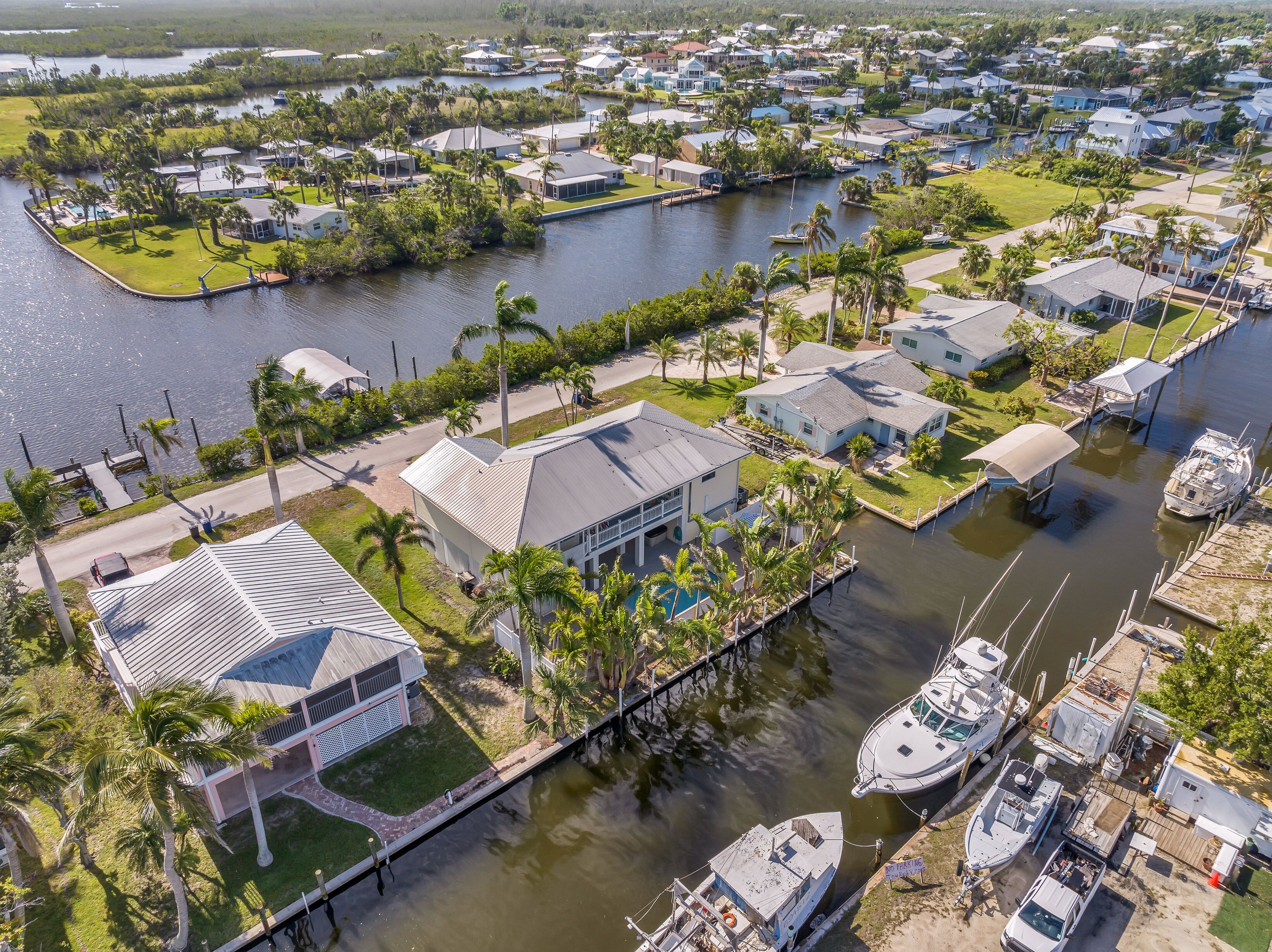 Vue aérienne d’un quartier résidentiel avec des maisons, un port de plaisance et une étendue d’eau.