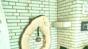 Una habitación con paredes de ladrillo blanco, una decoración circular de madera y un letrero que dice "Heim".