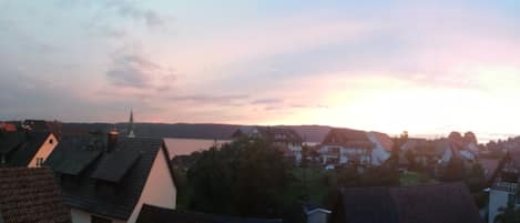 Blick auf eine Stadt mit traditionellen Häusern und einem Gewässer im Hintergrund.