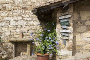 A stone building with a signpost indicating directions. - Chianti Villa and Pool for 12 (Siena)