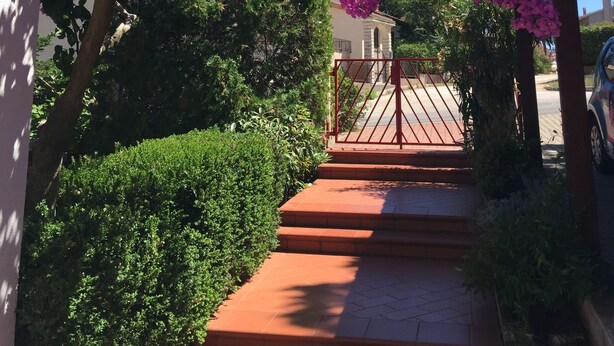 A pathway leading to a gated entrance with a building in the background.