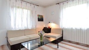 A living room with a sofa, a glass coffee table, and a lamp.