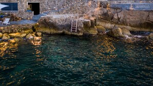 A coastal building with a balcony, outdoor seating, and a view of the sea. - Beachfront Villa Sorrento & private sea access (Sorrento)