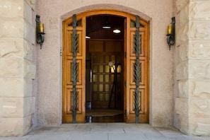 Stunning entrance with a double door and decorative iron gate.