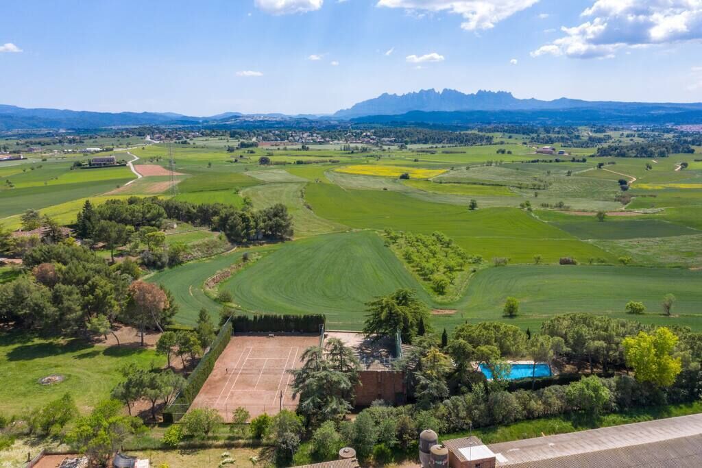 A golf course with a swimming pool, surrounded by green fields and trees.