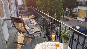 Un balcón con una mesa redonda, una silla y una planta en maceta.