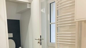 Un baño moderno con inodoro, ducha y zona de lavamanos.