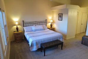 A bedroom with a bed, two bedside tables with lamps, a bench, a wardrobe, and a framed picture on the wall. - T4 Corner Moab Retreat with Private Garage in Rim Village (Moab)