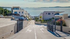 A modern residential area with a view of the sea, featuring contemporary architecture and a gated entrance. - Villa Le' Tini Luxury - Luxury Residence (Podstrana)