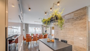 A modern kitchen with a central island, wooden flooring, and pendant lighting. - Villa Le' Tini Luxury - Luxury Residence (Podstrana)