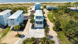 A coastal property with multiple buildings, a paved driveway, and a beach view. - One Wave or Another: Gulf Views, Private Pool, Putting Green (Indian Pass)