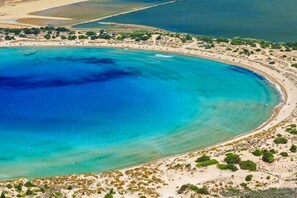 An aerial view of a coastal area with a large body of water, sandy beaches, and scattered vegetation. - Villa Vlassoula - Beachfront Luxury Villa with Private Pool & Garden Heaven (Kyparissia)
