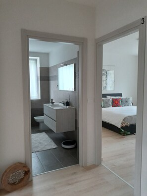 Une salle de bain moderne avec un lavabo, des toilettes et un miroir.