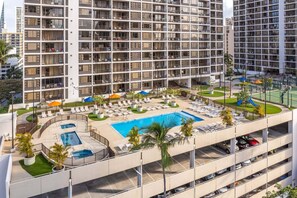A high-rise hotel with a rooftop pool, sun loungers, and a landscaped area. - Waikiki Banyan Condo With Panoramic 37th Floor Ocean Views (Honolulu)