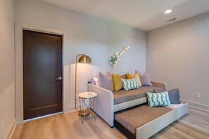A modern bedroom with a bed, bedside table, lamp, and a guitar decoration on the wall. - music city themed home with garage game room, sleeps 12 in east nashville (Nashville)