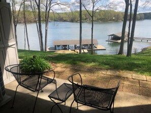 A patio with two metal chairs and a small table, overlooking a lake with a dock and a building. - What A View, Wifi, ping pong, cloe to amenities (Moneta)