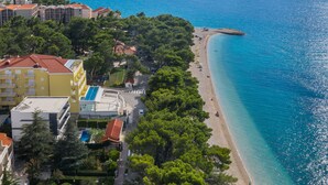 Um hotel à beira-mar, com vários edifícios, praia e vista clara para o oceano.