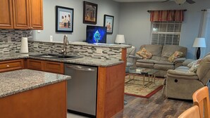 A modern kitchen with granite countertops, wooden cabinets, and a built-in dishwasher. - 4106 Palms, 1st floor, 3-bedroom, 2-bath, Aug and Sept weekends still available (Rehoboth Beach)