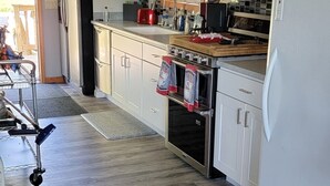 Eine moderne Küche mit weißen Schränken, einem Edelstahl-Kühlschrank, einer Mikrowelle und einem Geschirrspüler.
