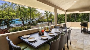 A dining area with a view of the ocean, outdoor grill, and seating with a view.