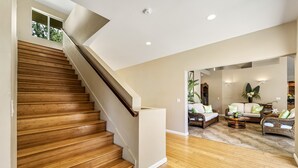 A wooden staircase leading to a living area with a sofa set and a coffee table.
