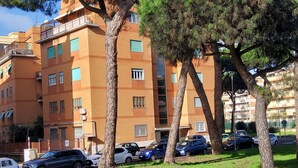 A multi-story residential building with a parking area in front.