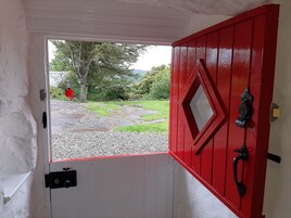A red door with a diamond-shaped window, a black handle, and a keyhole.