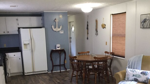 A compact living space with a kitchen, dining area, and a small seating area. - Country living lake style near Santee  (Summerton)