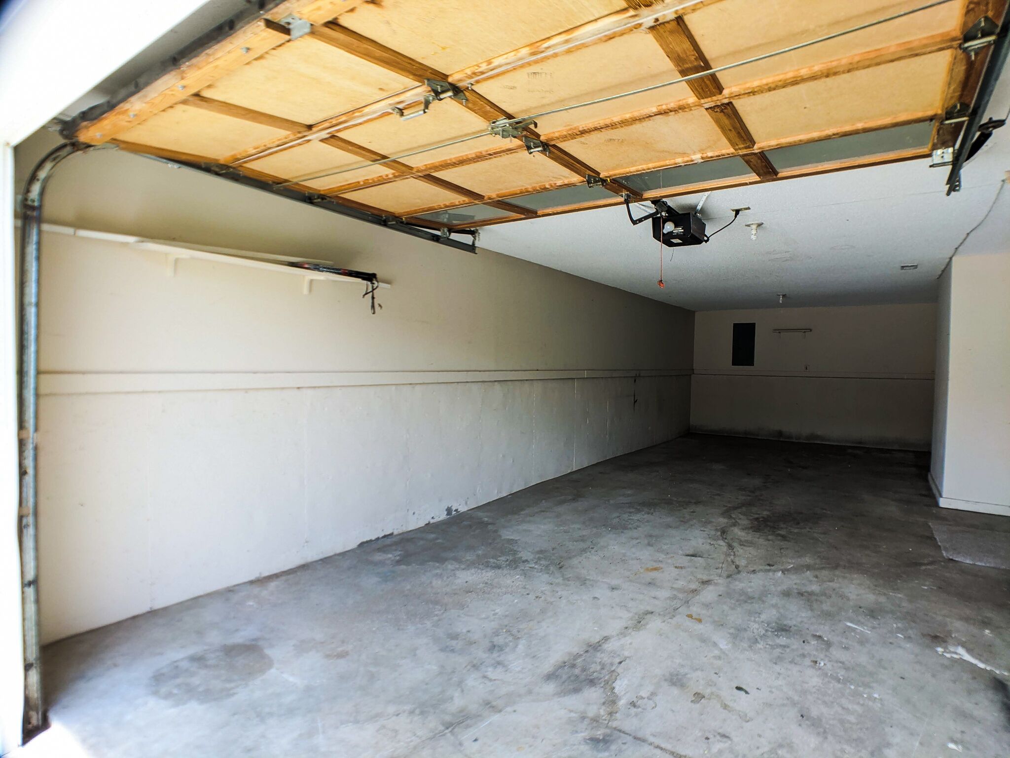 A garage with a concrete floor and a wooden ceiling.