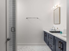 A modern bathroom with a shower, a sink, and a mirror. - Casa Paradisa • Rooftop, Fire Pit, Skyline Views (Nashville)
