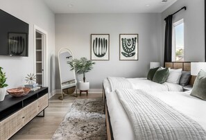 A modern bedroom with a bed, bedside tables, a mirror, and artwork on the wall.