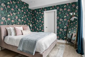 A bedroom with a bed, a mirror, and a door. - Casa Paradisa • Rooftop, Fire Pit, Skyline Views (Nashville)