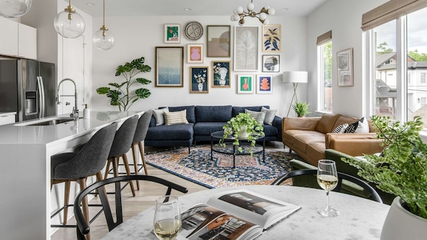 A modern living room with a sofa, coffee table, and a dining area with chairs and a table. - Casa Paradisa • Rooftop, Fire Pit, Skyline Views (Nashville)