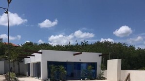 A modern pool area with a rectangular pool, a white building with large windows, and a clear blue sky. - LUXURY EN EL MONUMENTO DE SANTIAGO DE LOS CABALLEROS (Santiago De Los Caballeros)