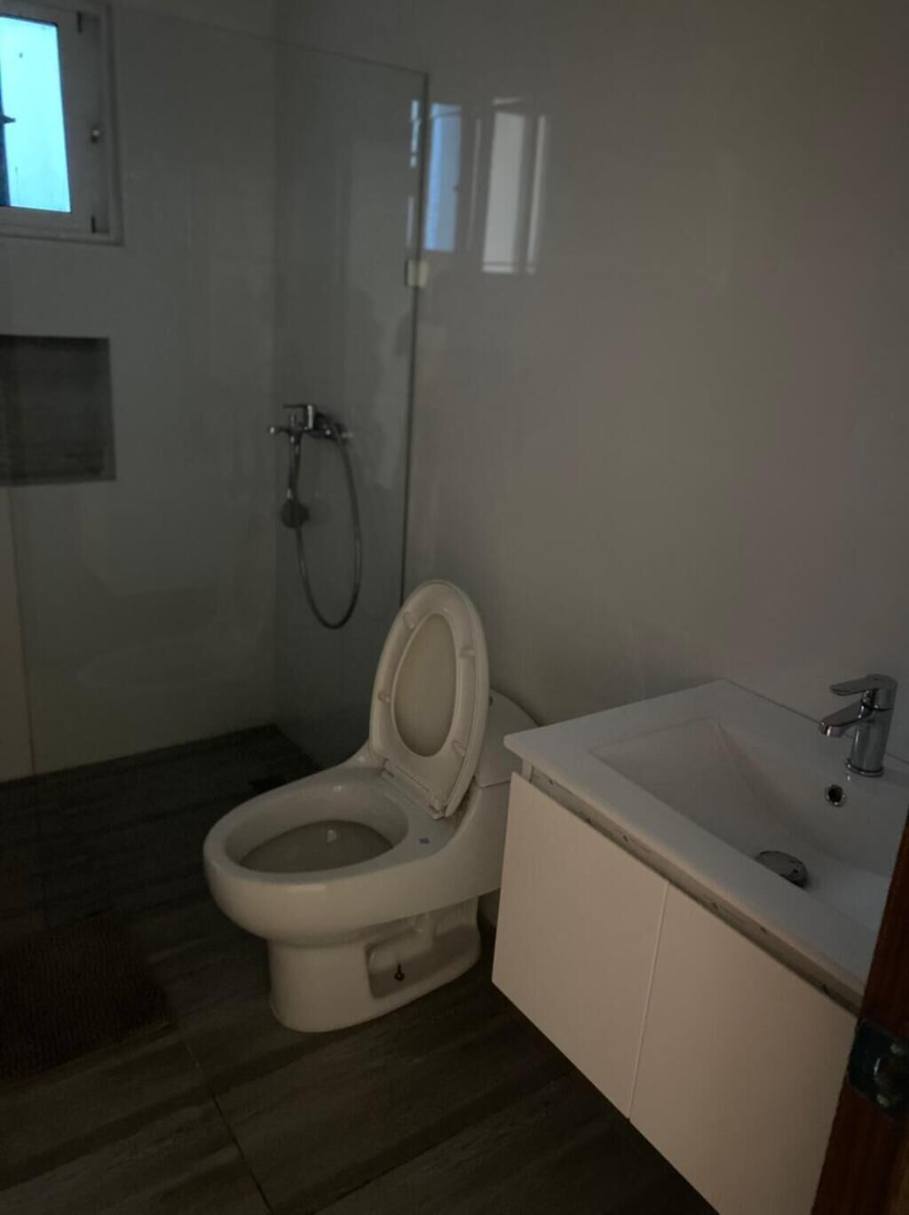 Pieni kylpyhuone, jossa on wc, suihku ja pesuallas.