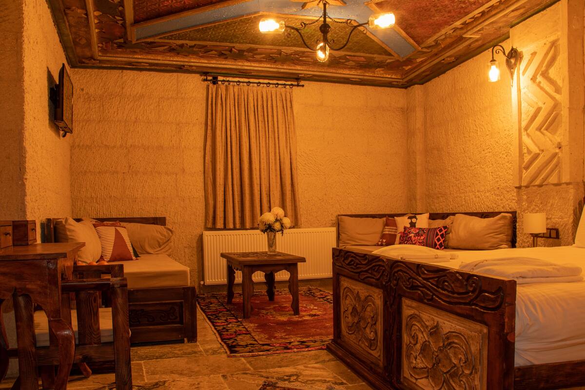 A cozy room with a wooden bed, a small table, a chair, and a radiator.