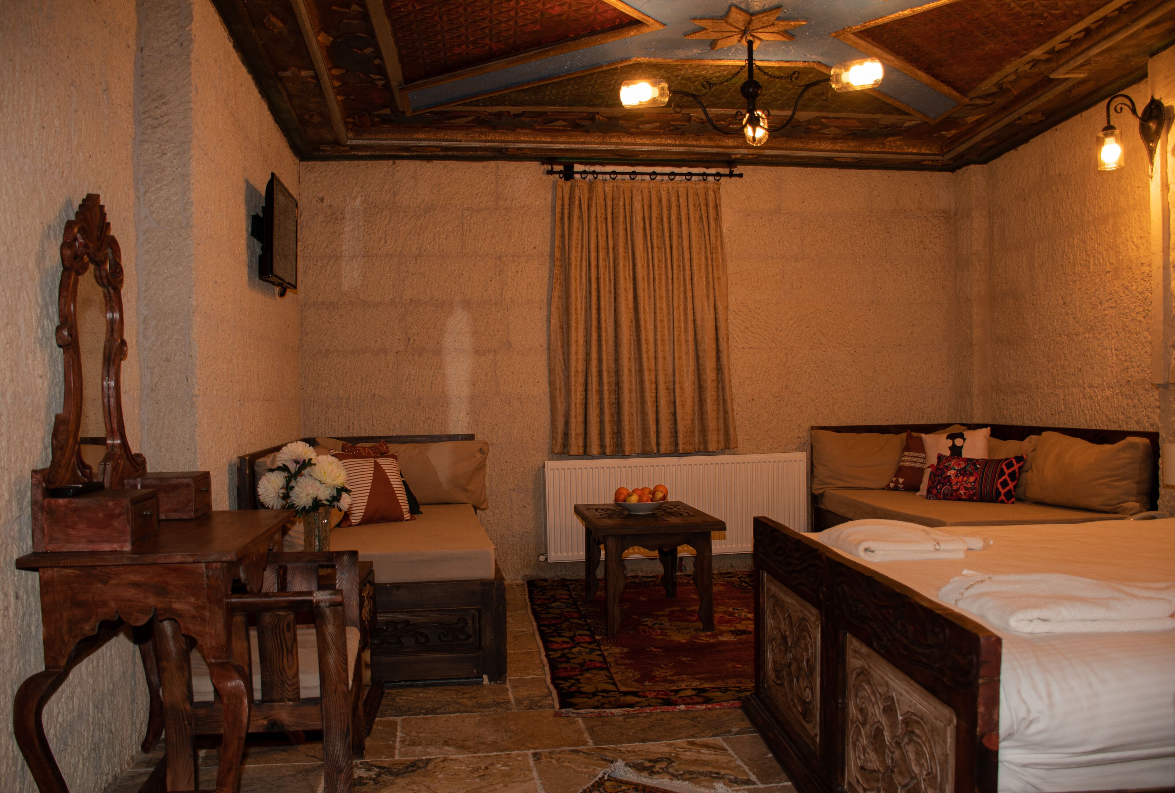 A cozy room with a bed, a sofa, a wooden table, and a chair.