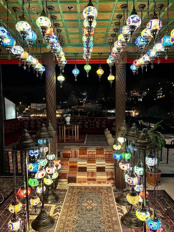 Un restaurante con faroles colgantes de colores y una alfombra estampada.