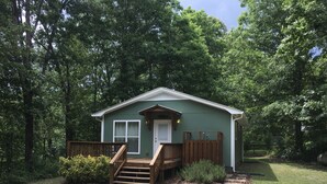 A small, single-story house with a front porch and a staircase leading to the entrance. - Scout's Hideaway on Beautiful Smith Lake (Arley)