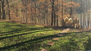 A wooden bridge over a lake, surrounded by trees and grass. - Scout's Hideaway on Beautiful Smith Lake (Arley)