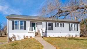 A single-story house with a front porch, a driveway, and a lawn. - Carter Street | Walkable Crozet | Pet-Friendly (Crozet)