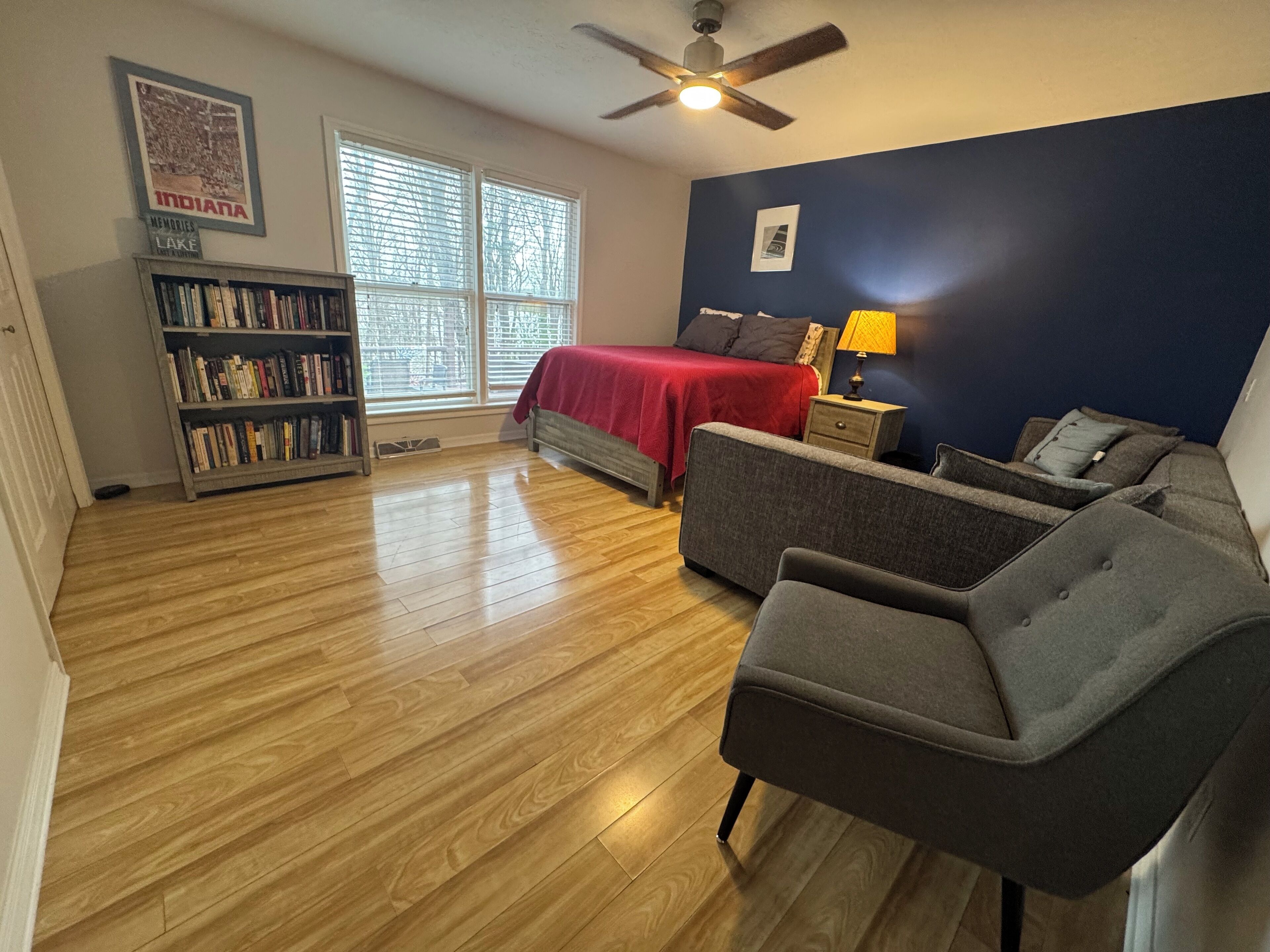 Une chambre à coucher avec un lit, une bibliothèque, un bureau et une chaise.