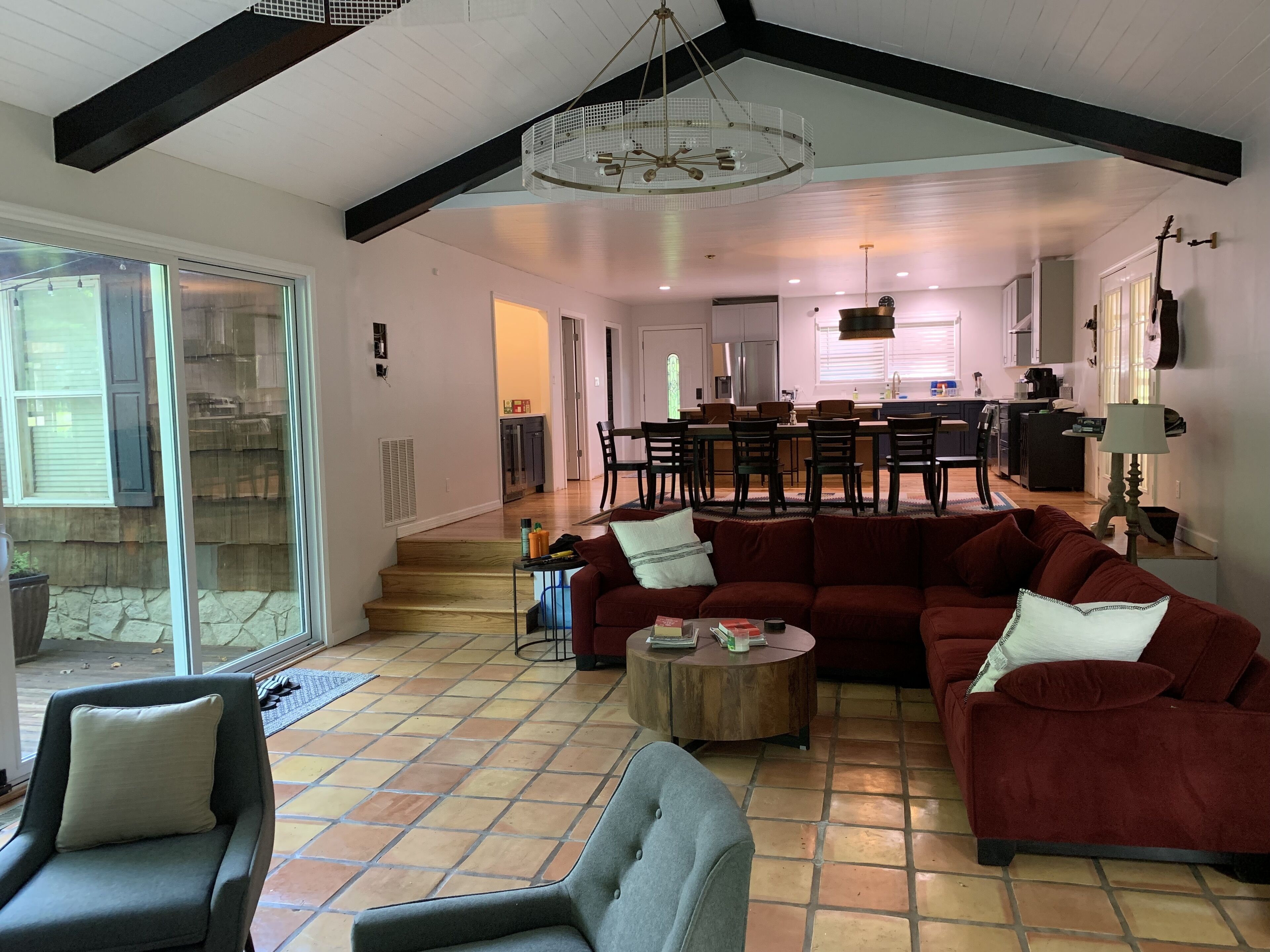 A spacious living room with a large sectional sofa, a coffee table, and a dining area in the background.
