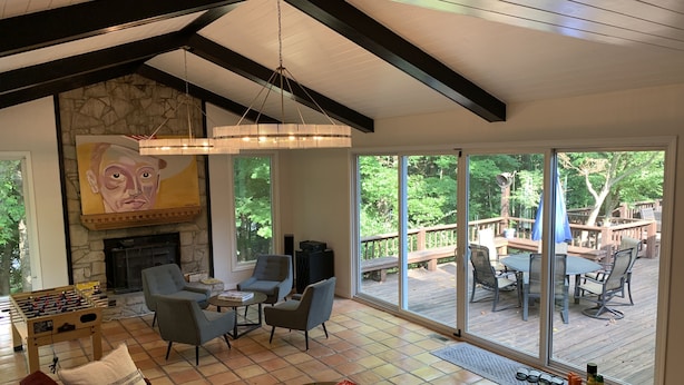 A spacious living room with a fireplace, comfortable seating, and a large sliding glass door leading to an outdoor deck.