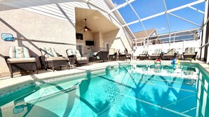 Une piscine équipée de chaises longues et d’un ventilateur de plafond.