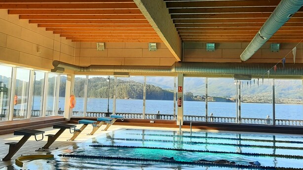 An indoor swimming pool with clear views of a lake and mountains. - Country house with gate next to the sea (Santa Marta de Ortigueira)