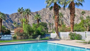 A pool with clear blue water, surrounded by palm trees and a mountain backdrop. - PGA WEST PALMER GATE - 9TH HOLE - JUST FORE FUN  (La Quinta)