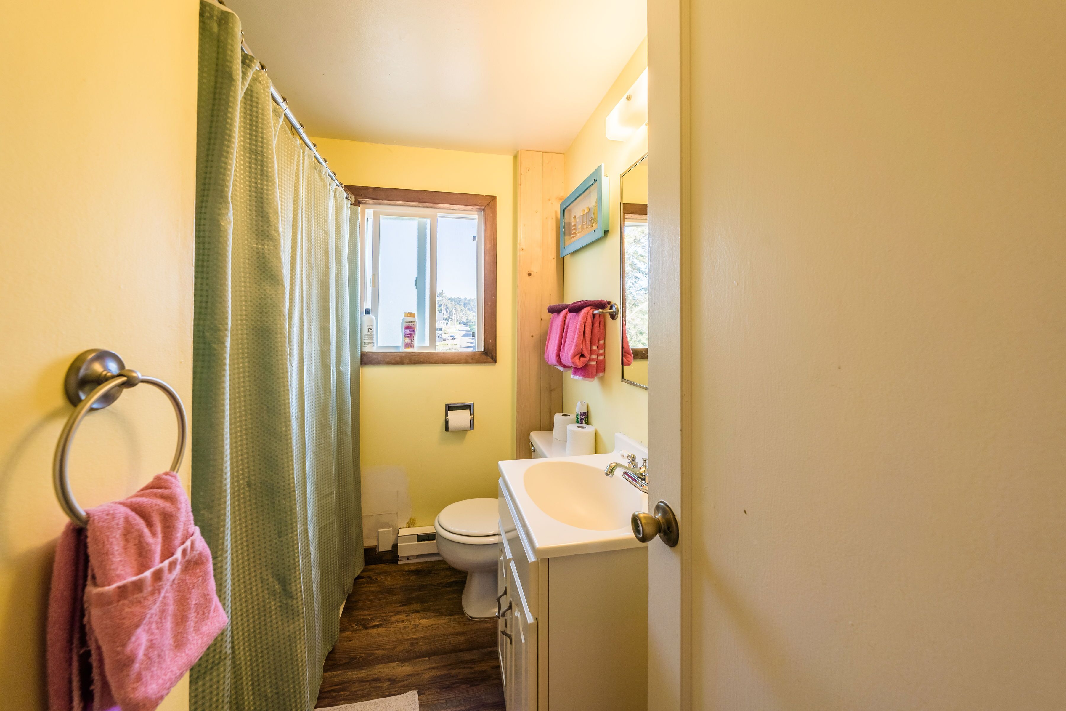 Un baño pequeño con inodoro, lavamanos y cortina de ducha.