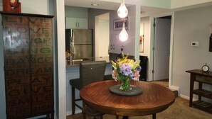 A dining area with a wooden table, chairs, a vase with flowers, and a kitchen in the background. - 1 Bedroom, 1 bath townhouse in The Galena Territory. (Galena)