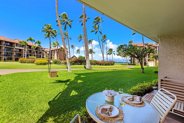 Una mesa colocada al aire libre con vista a un hotel y palmeras.